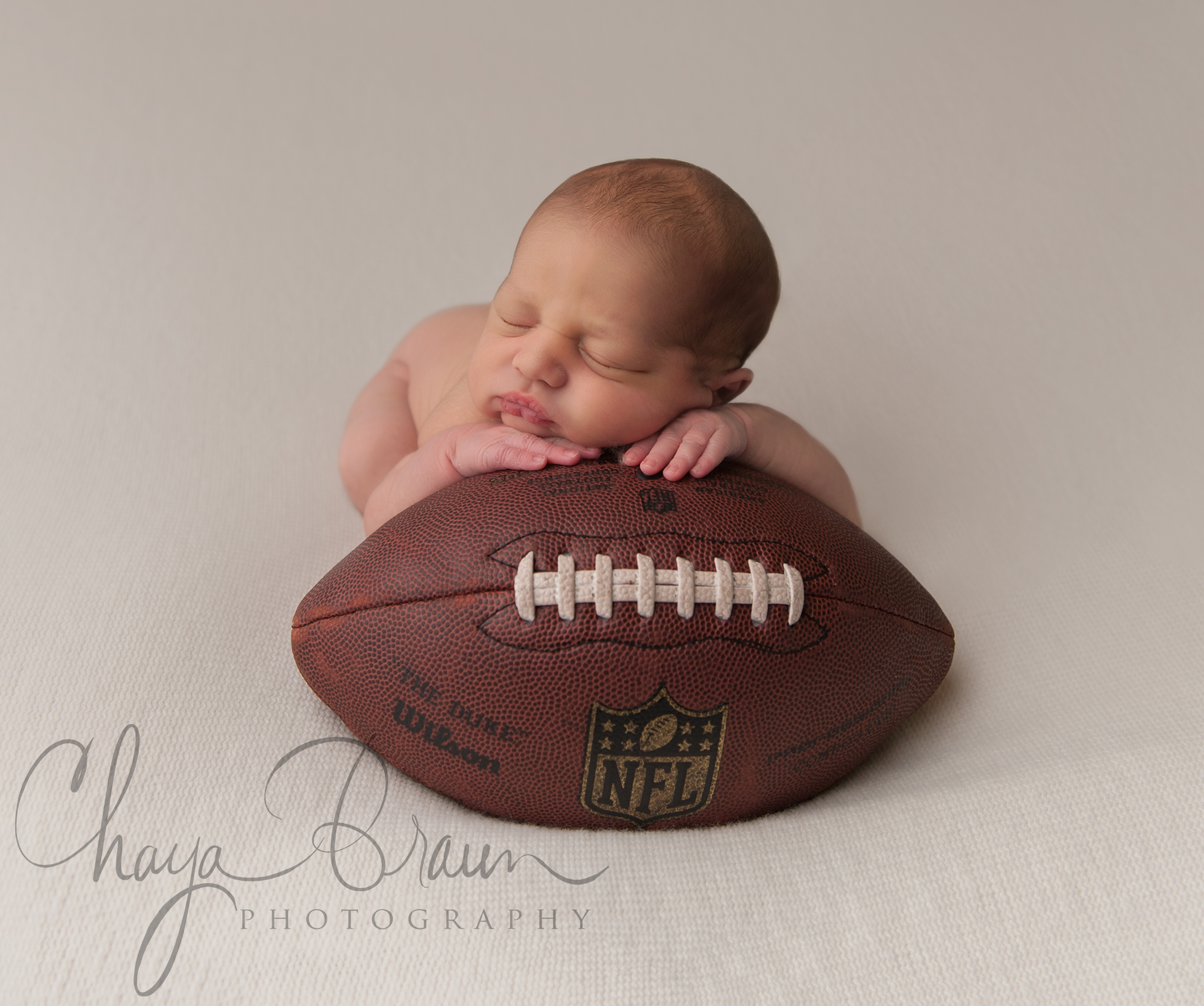 newborn baby on football