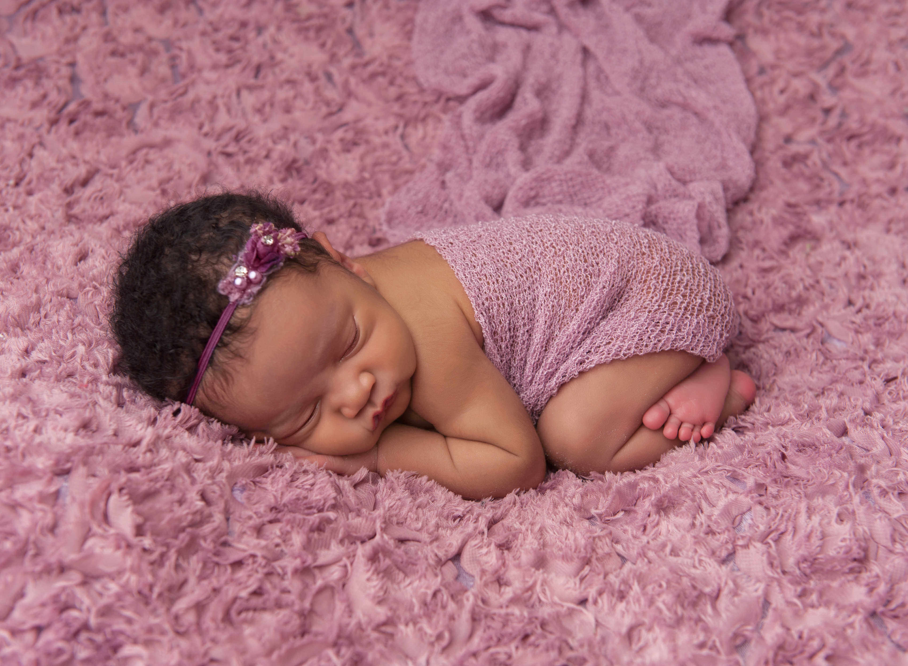 sleeping newborn baby on purple blanket