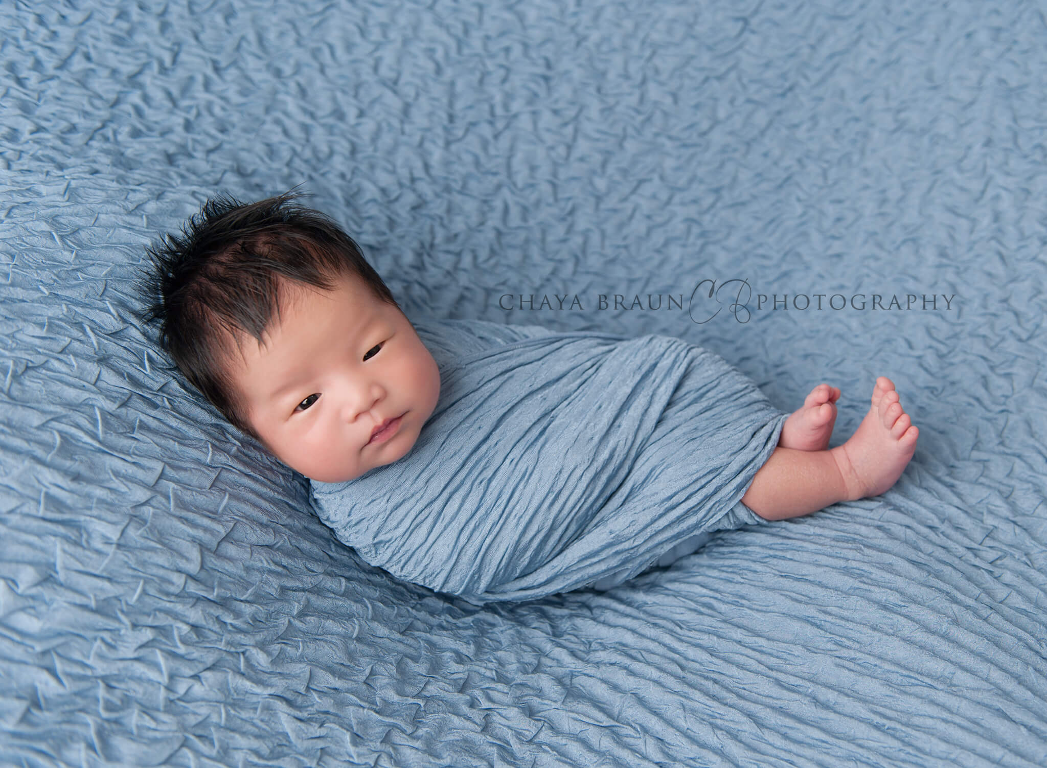 newborn swaddled in blue