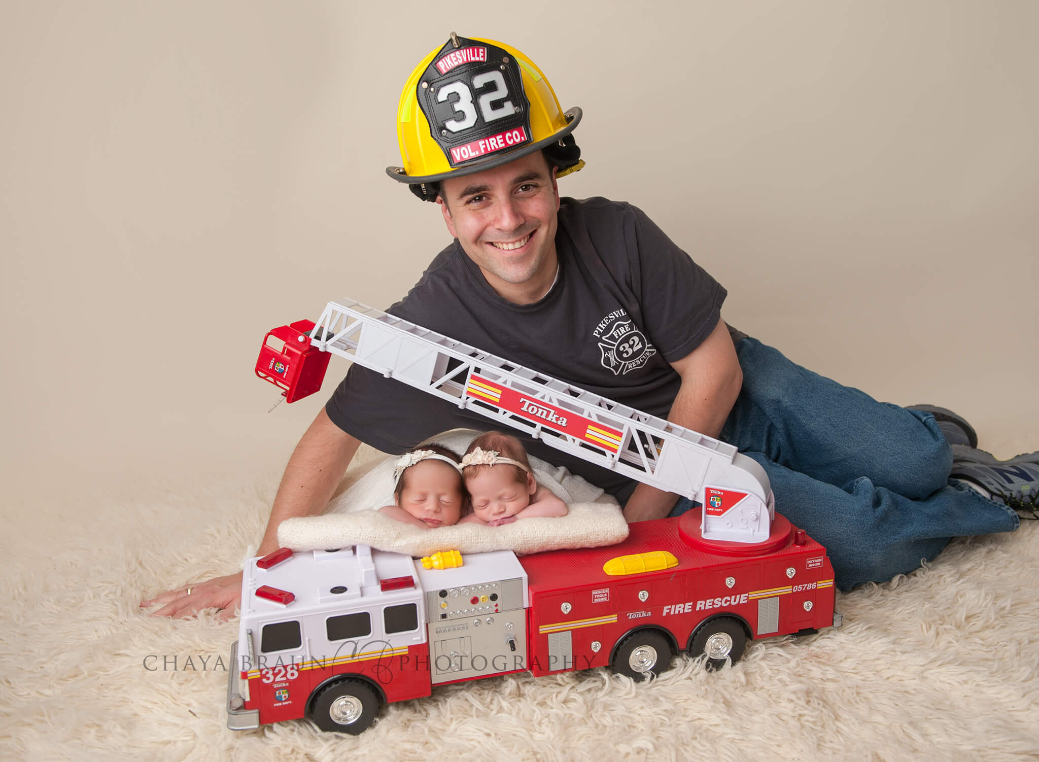 newborn twin babies with firefighter dad