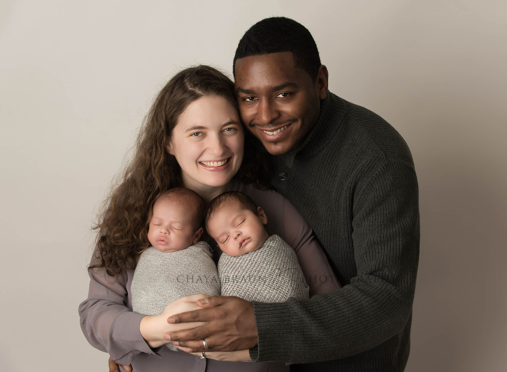 parents holding newborn twins photography