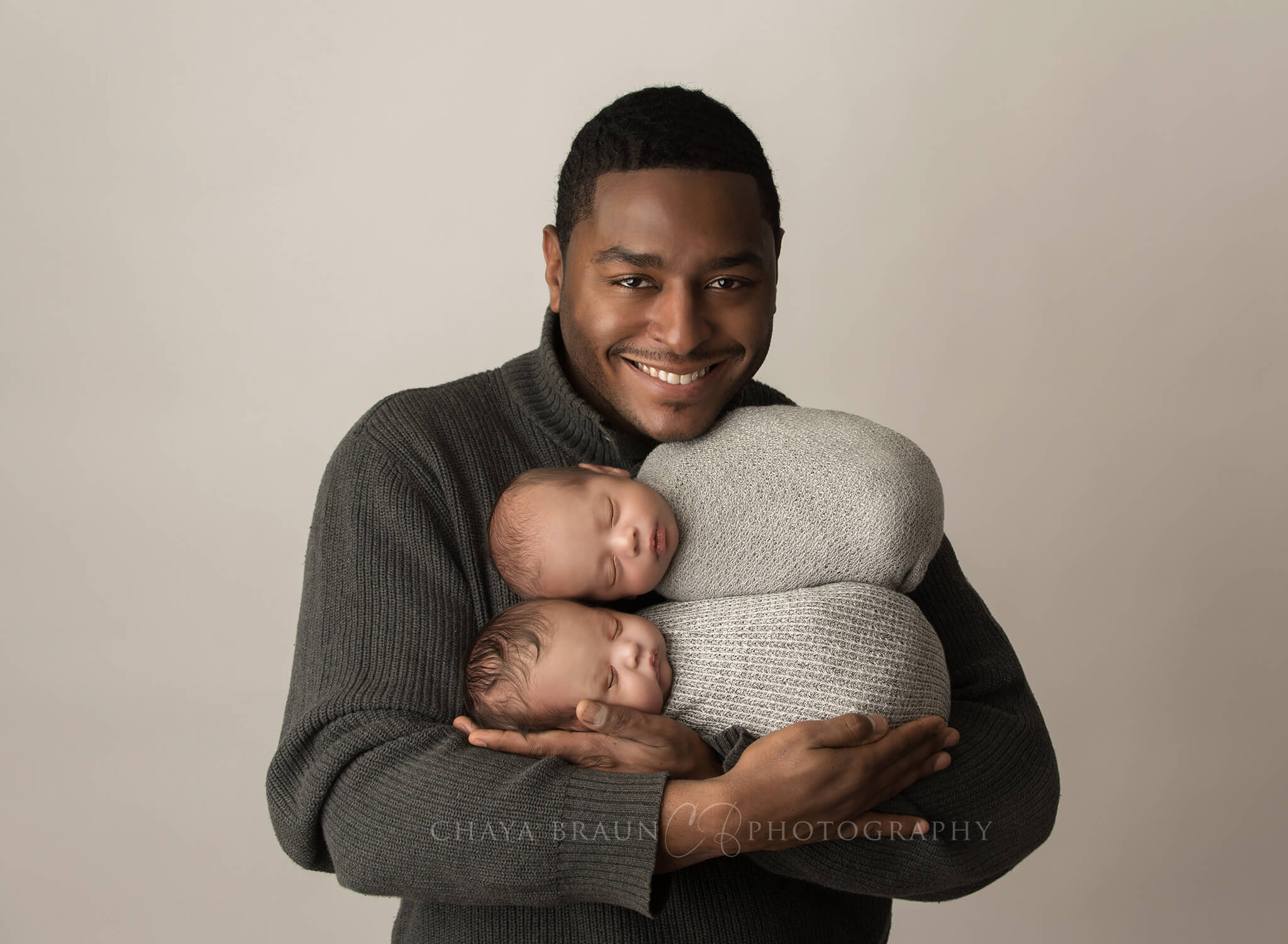 dad holding newborn baby twins