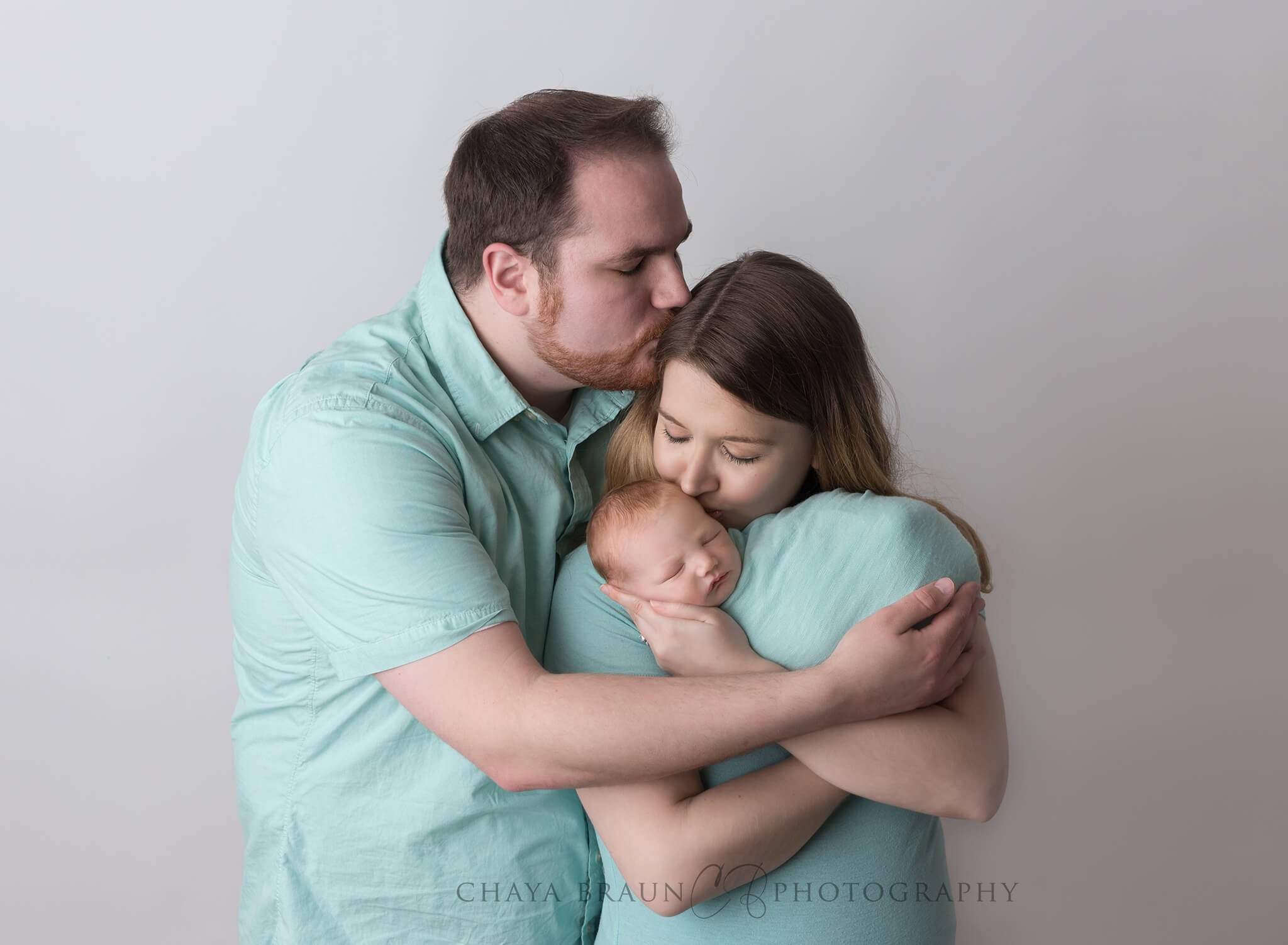 newborn baby and family kissing