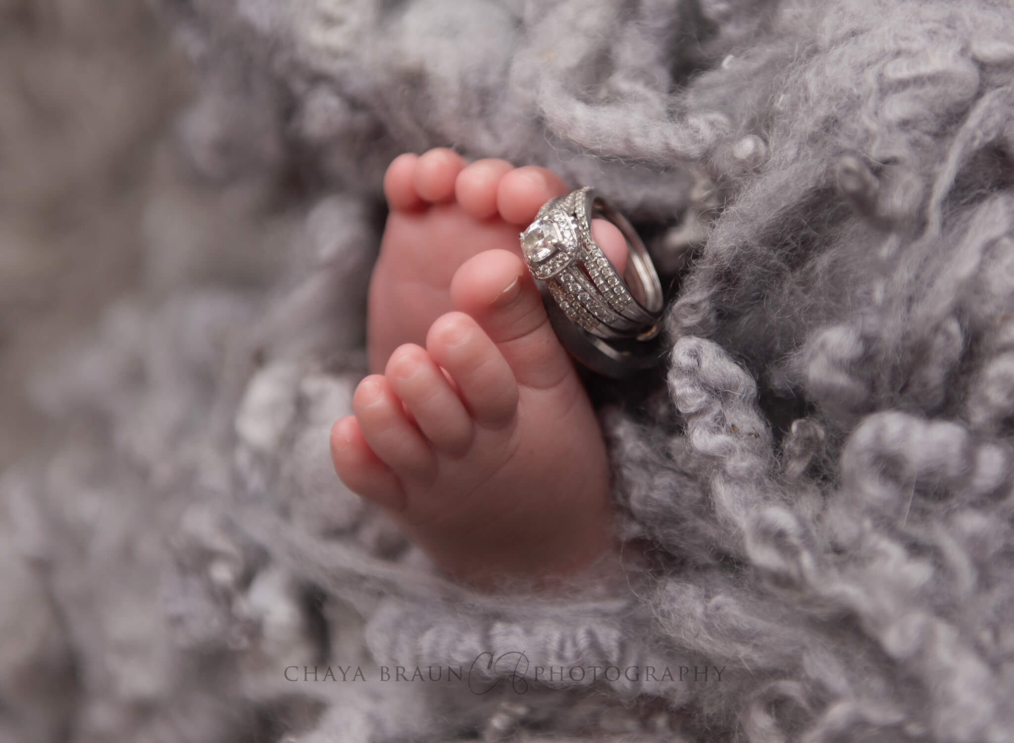 newborn baby with wedding rings